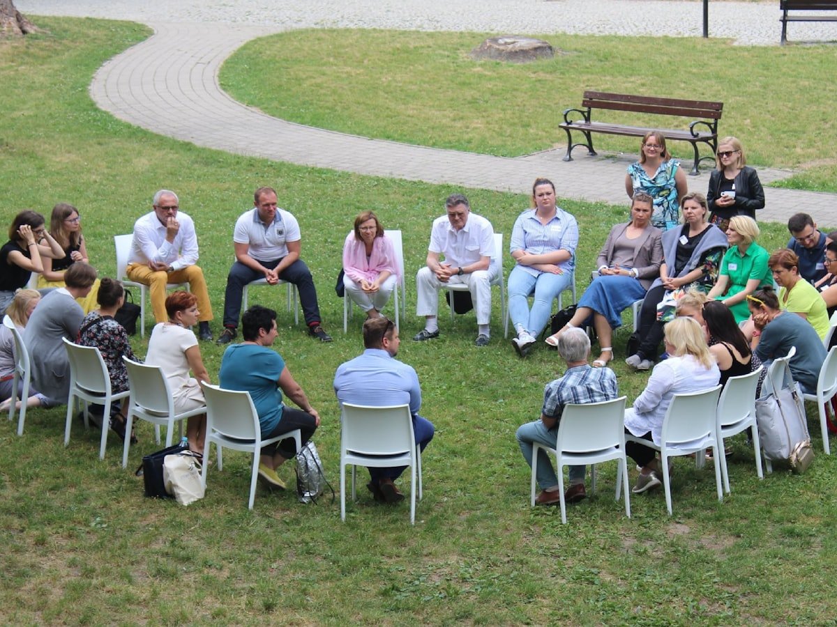 A small group sitting in a circle outdoors